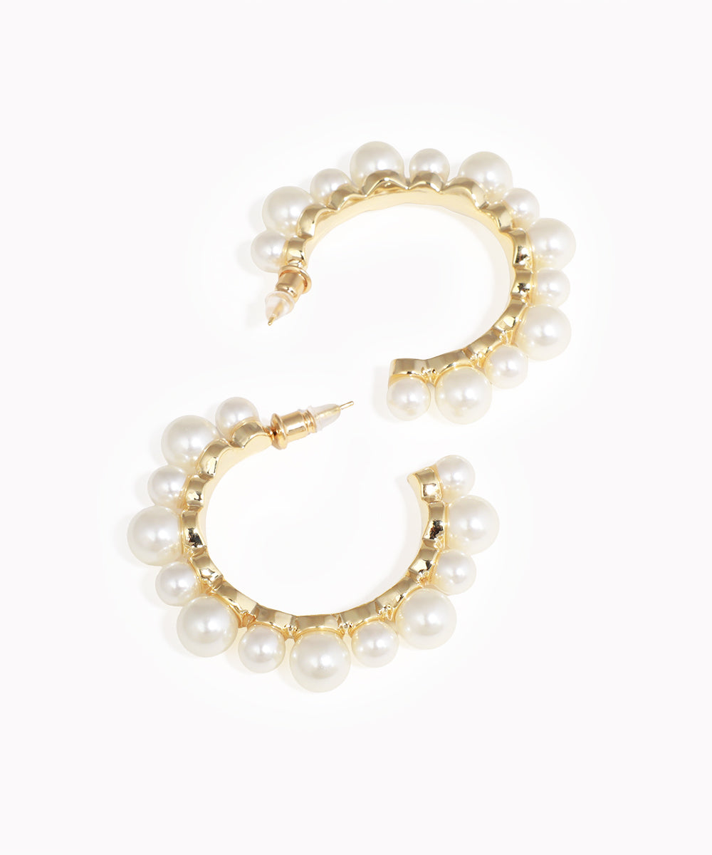 Gold-tone earrings with faux pearls in a curved half hoop design