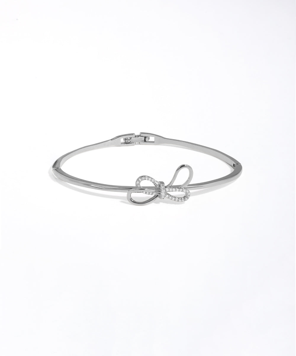 Silver bracelet with bow design on a white background