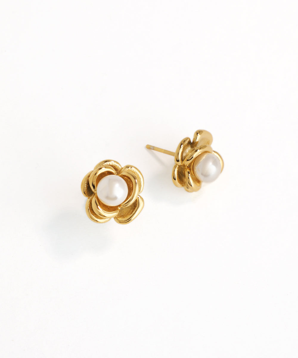 Gold flower-shaped earrings with pearl centers on a white background