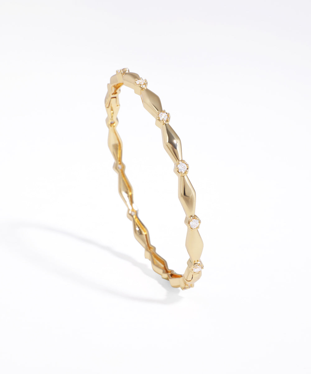 Gold-tone bracelet with geometric faceted links and small clear cubic zirconia stones