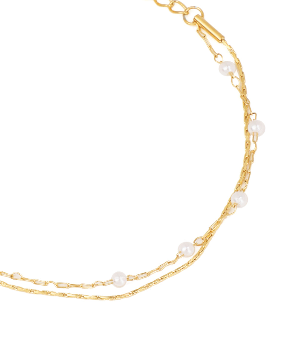 Gold chain necklace with pearls on a white background