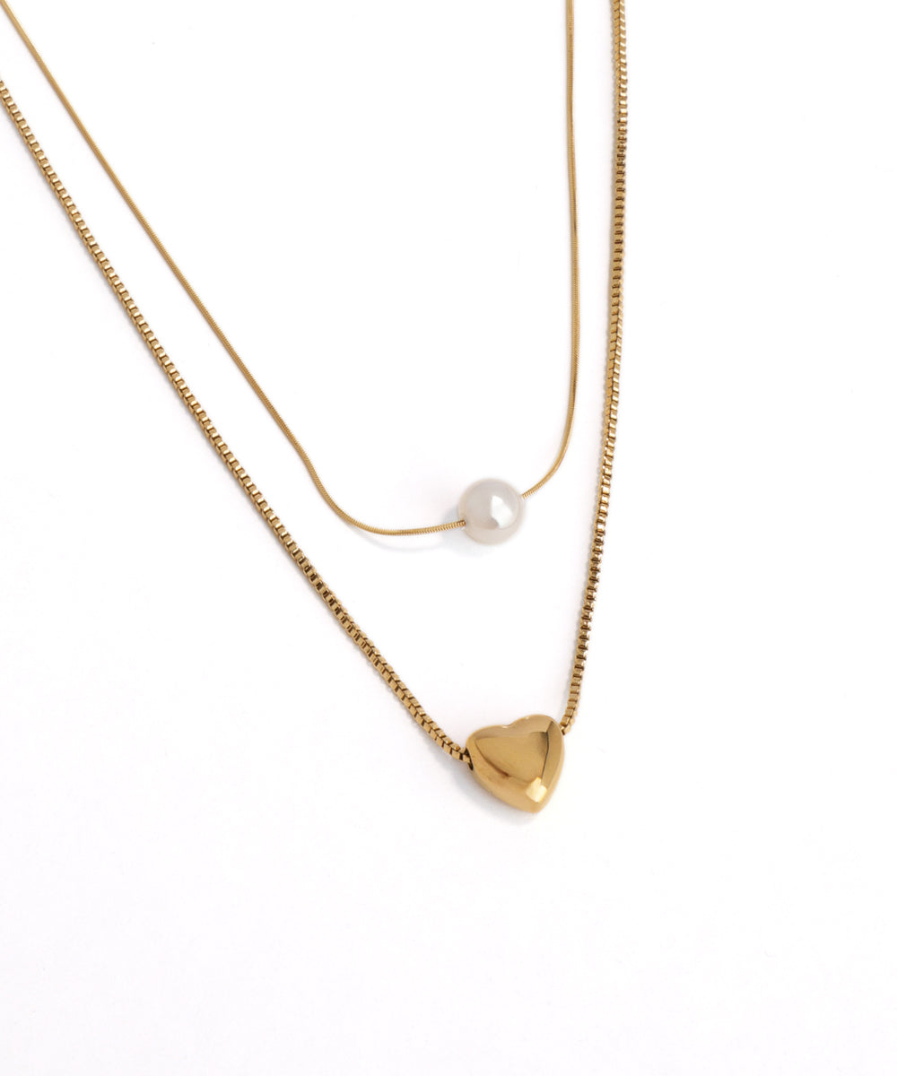 Gold necklace with a heart pendant on a white background