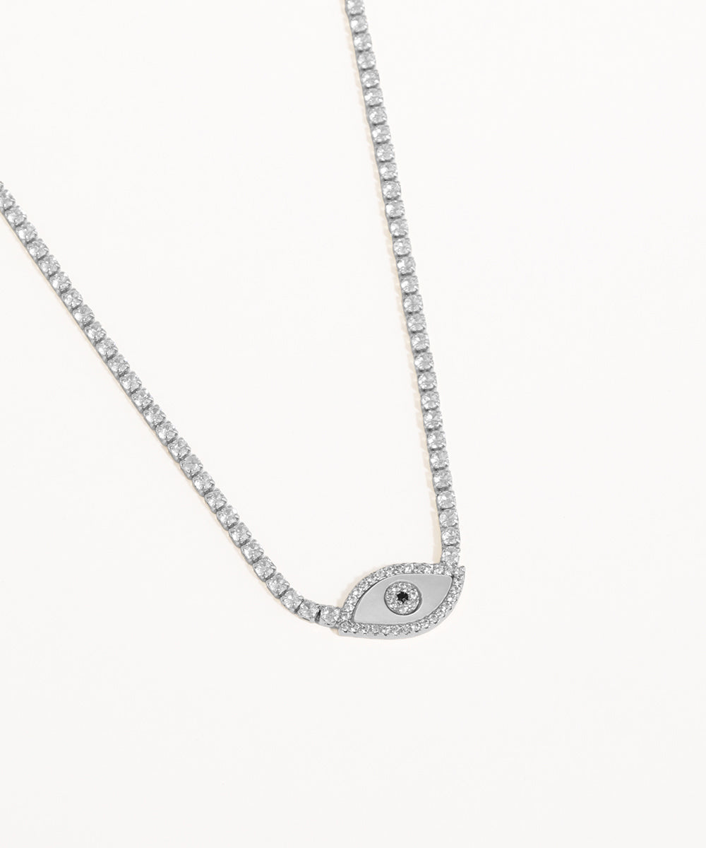 Silver necklace with a small evil eye pendant on a white background