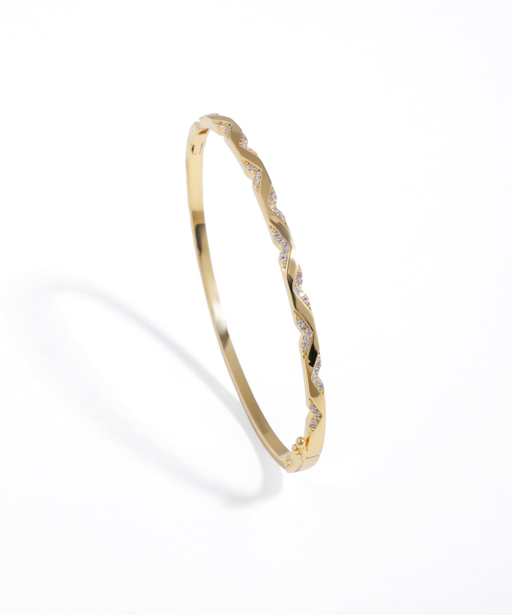 Gold-tone bracelet with a twisted design and clear sparkling stones