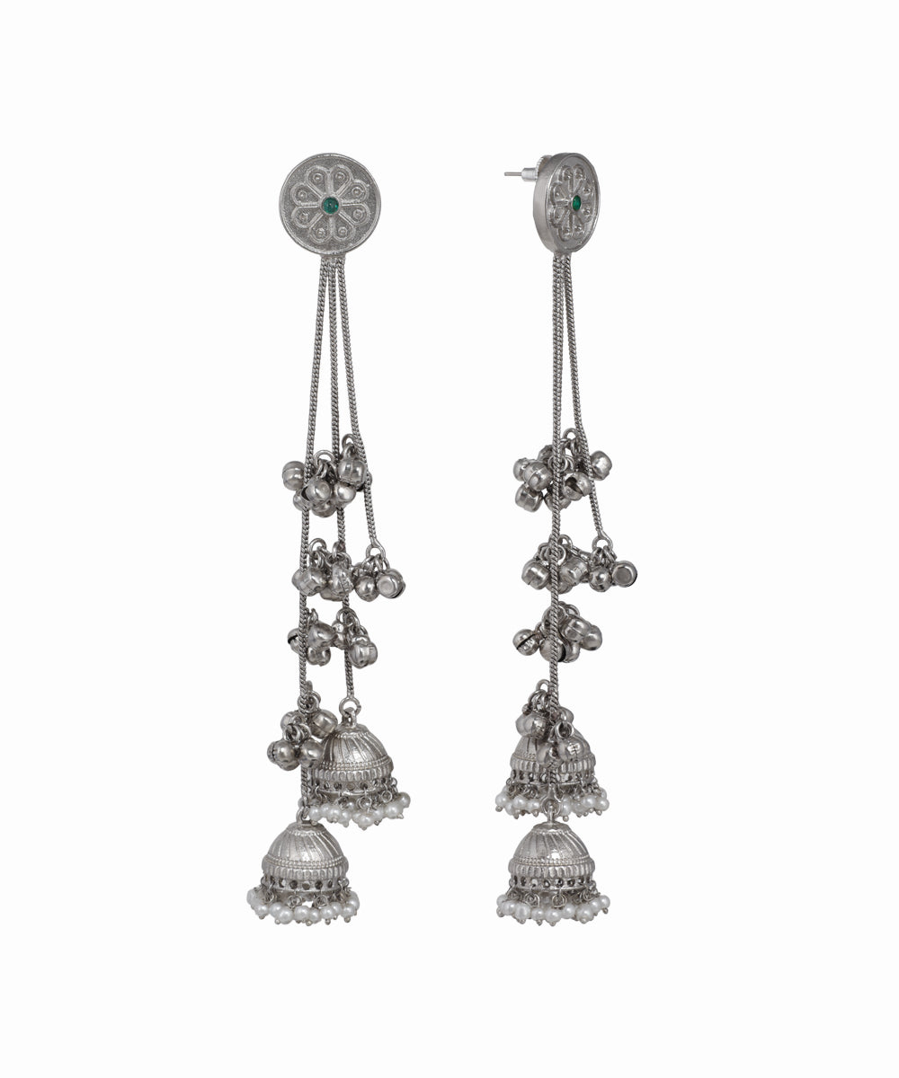 Pair of silver earrings with hanging components on a white background