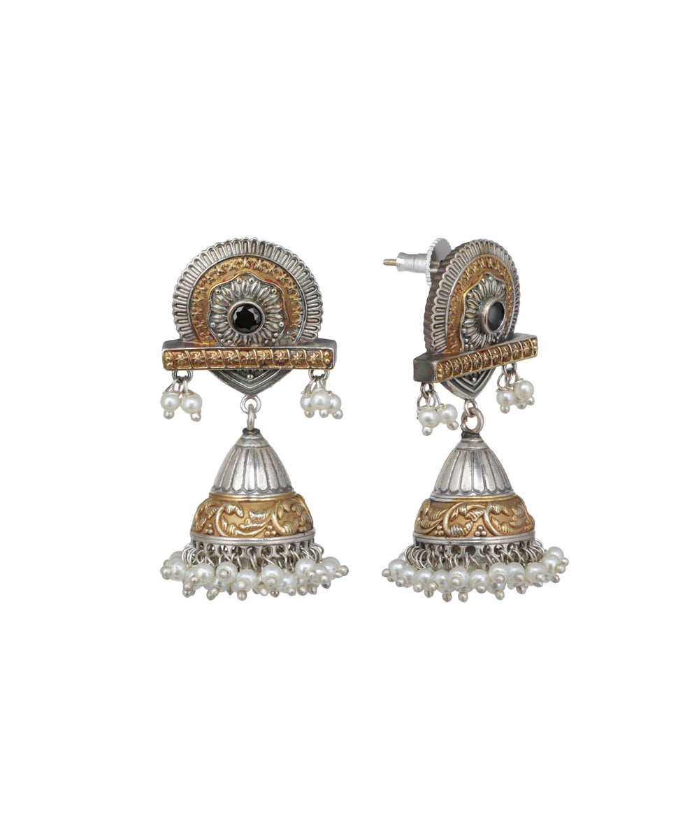Pair of ornate earrings with gold and silver design on a white background