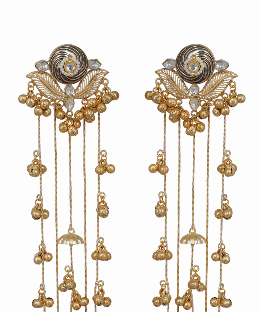Pair of gold and silver earrings with intricate designs on a white background