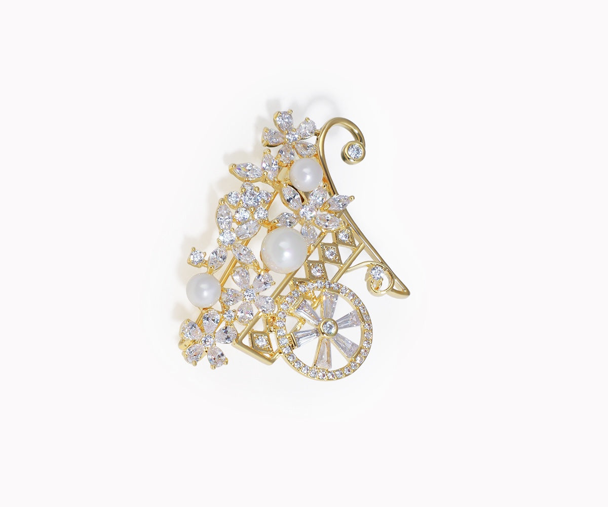 Gold brooch with pearls and crystals on a white background