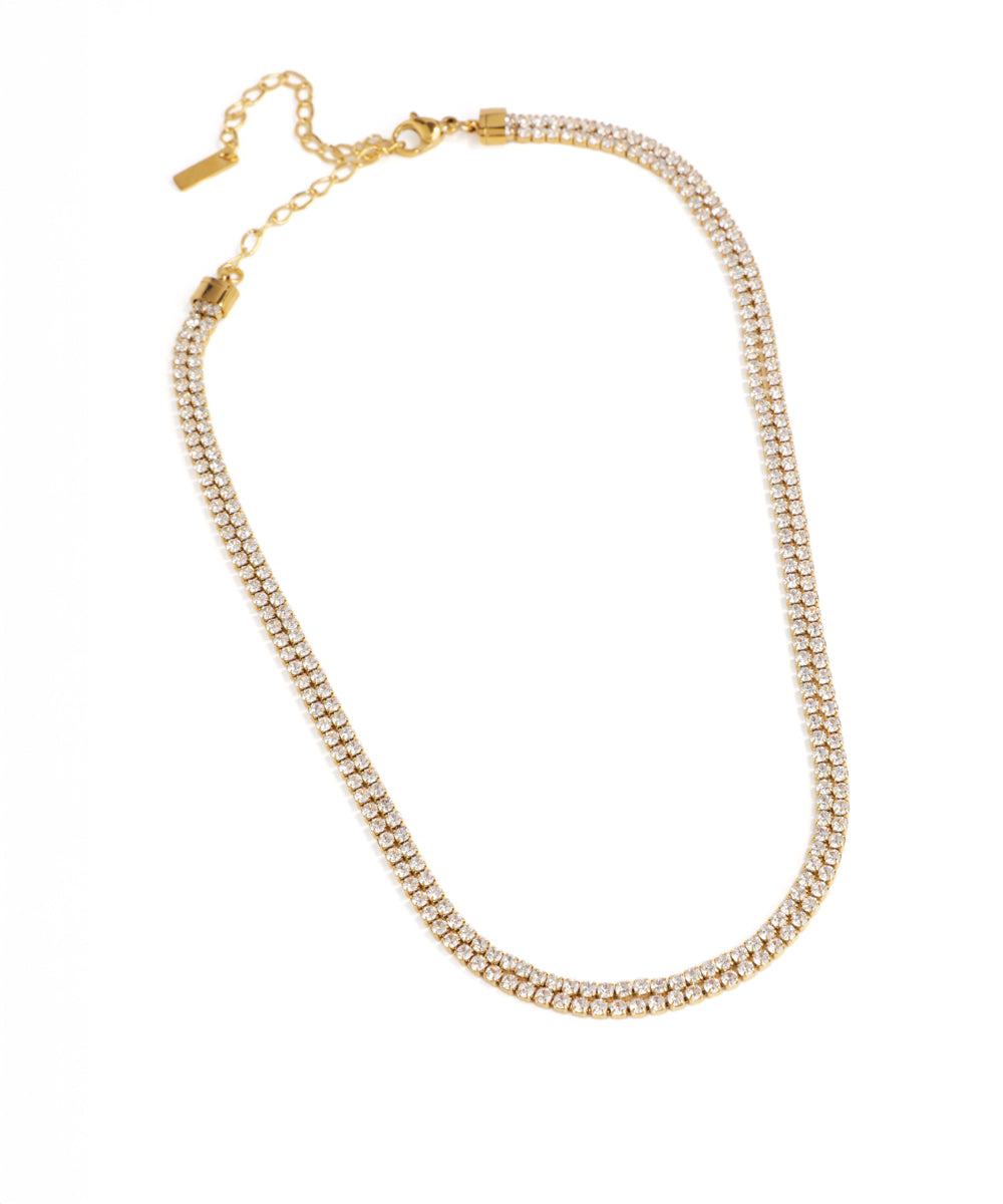 Gold necklace with clear beads on a white background