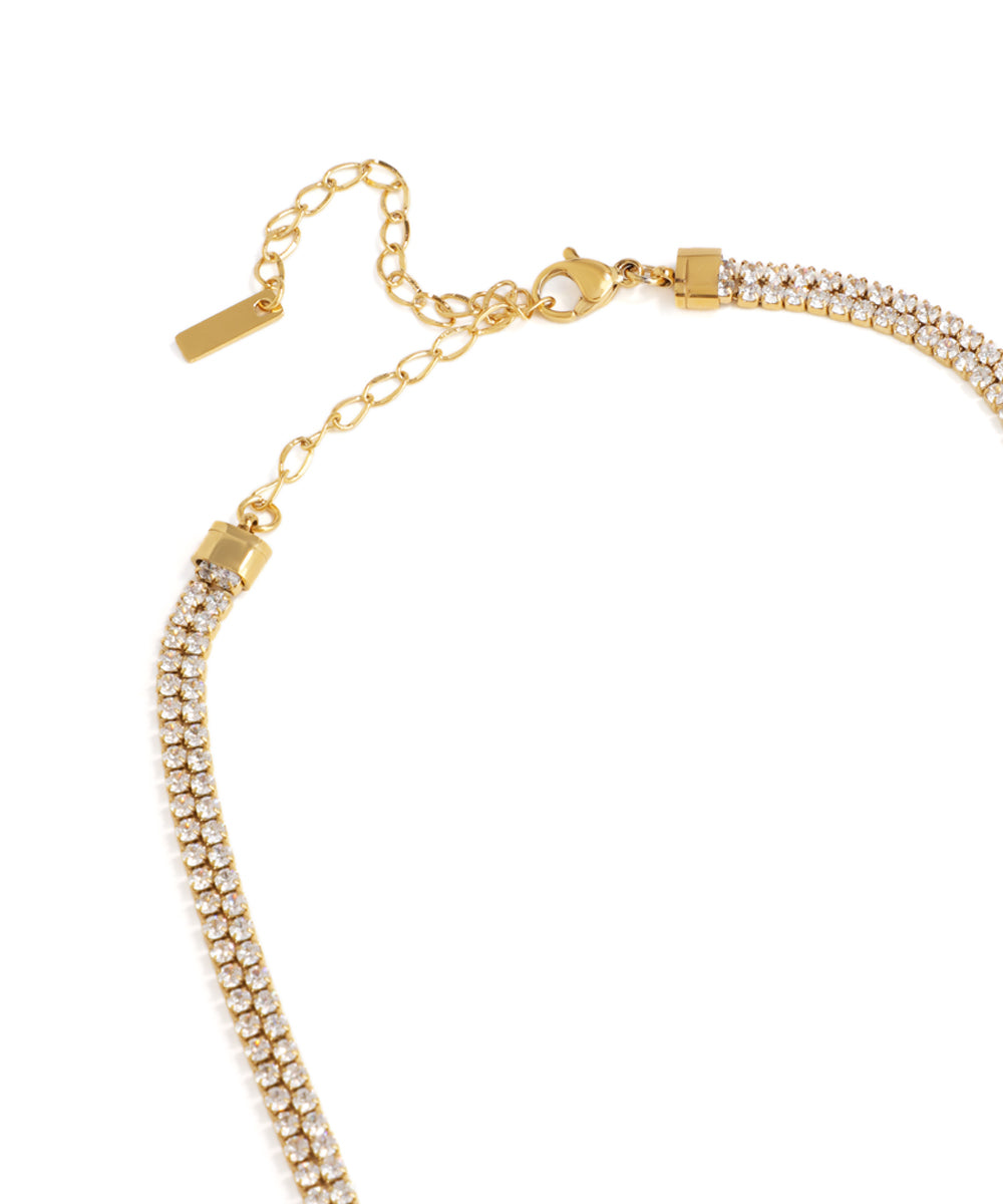 Gold bracelet with clear stones on a white background
