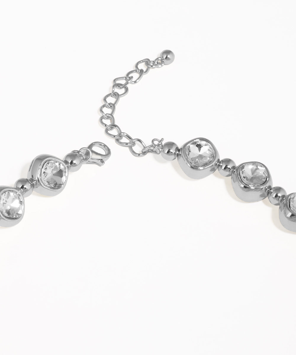 Silver bracelet with clear gemstones on a white background