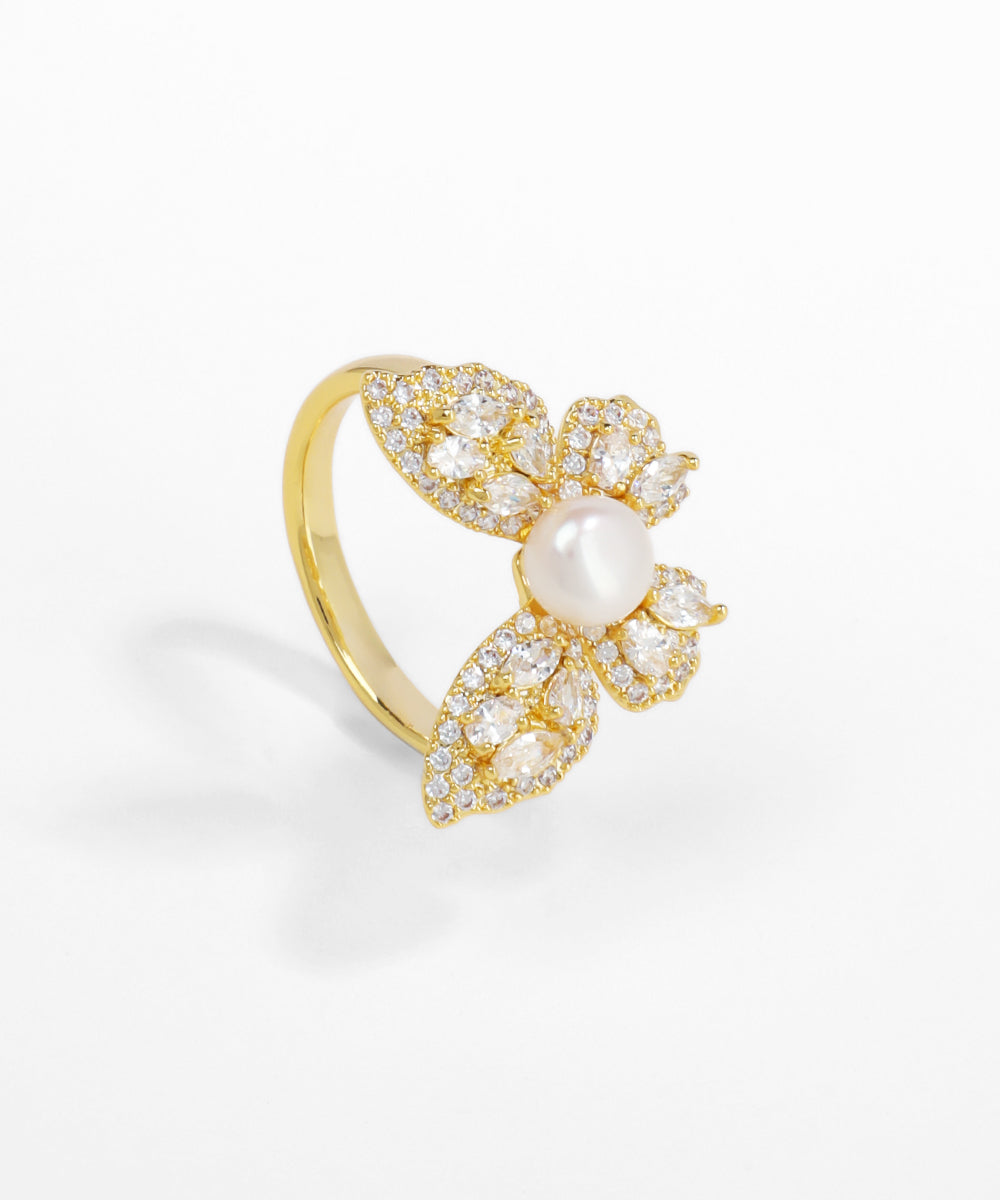 Gold ring with pearl and crystals on a white background