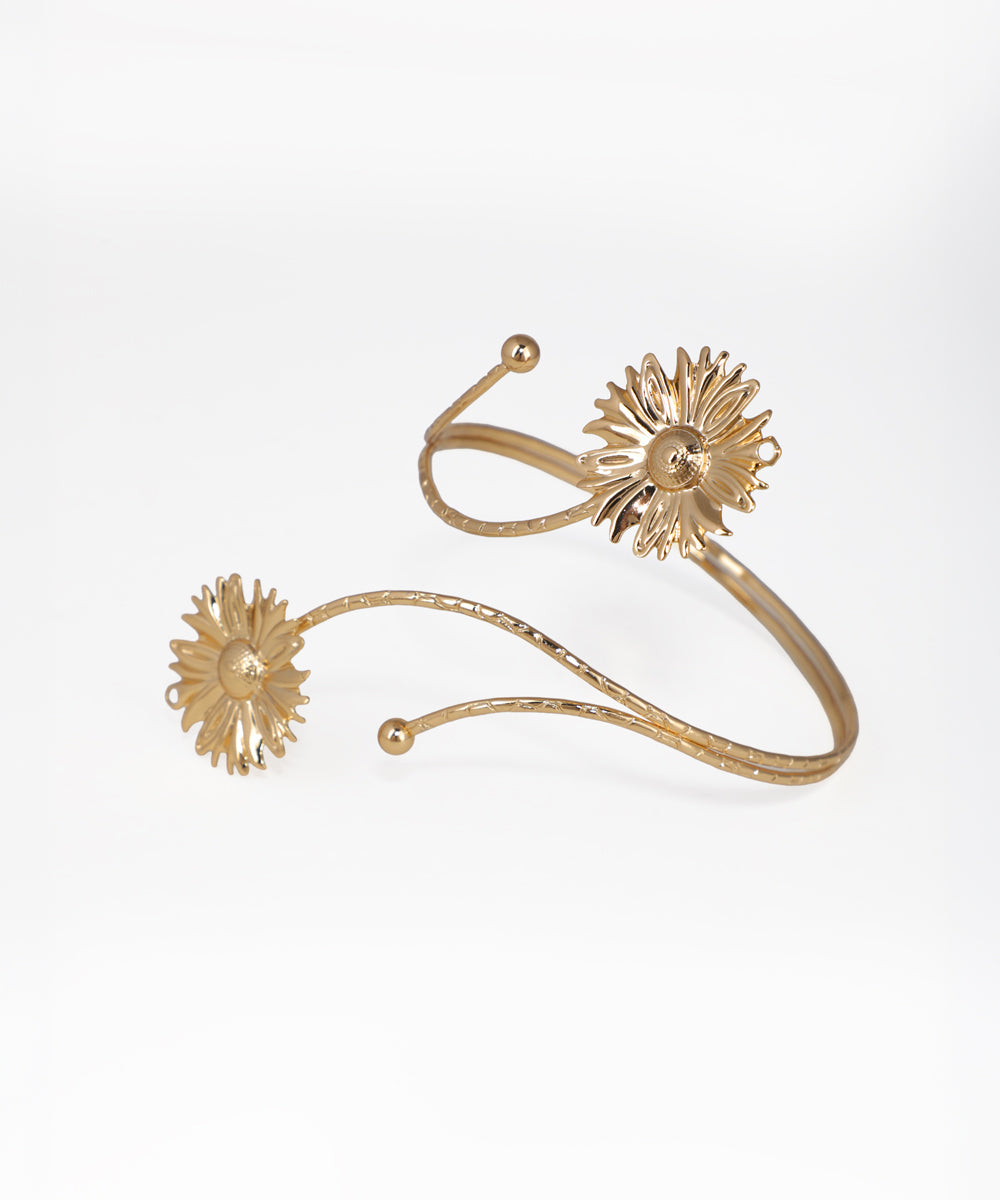 Gold floral cuff bracelet on a light gray background