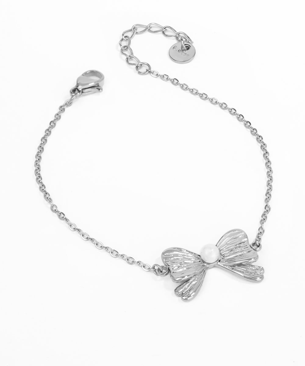 Silver bracelet with a bow-shaped charm on a white background