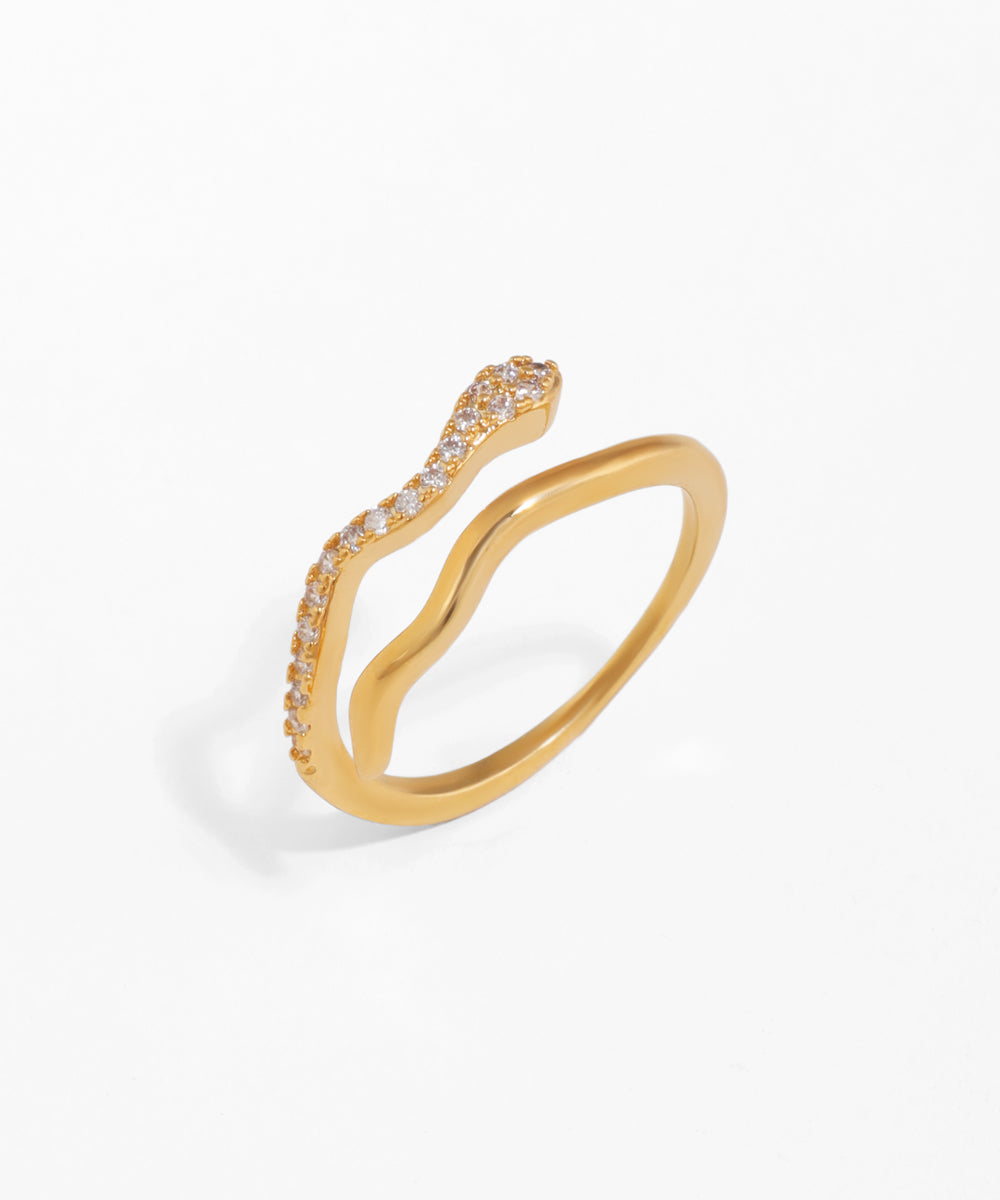 Gold-tone open ring with a curved wave design and clear cubic zirconia stones set along one edge.