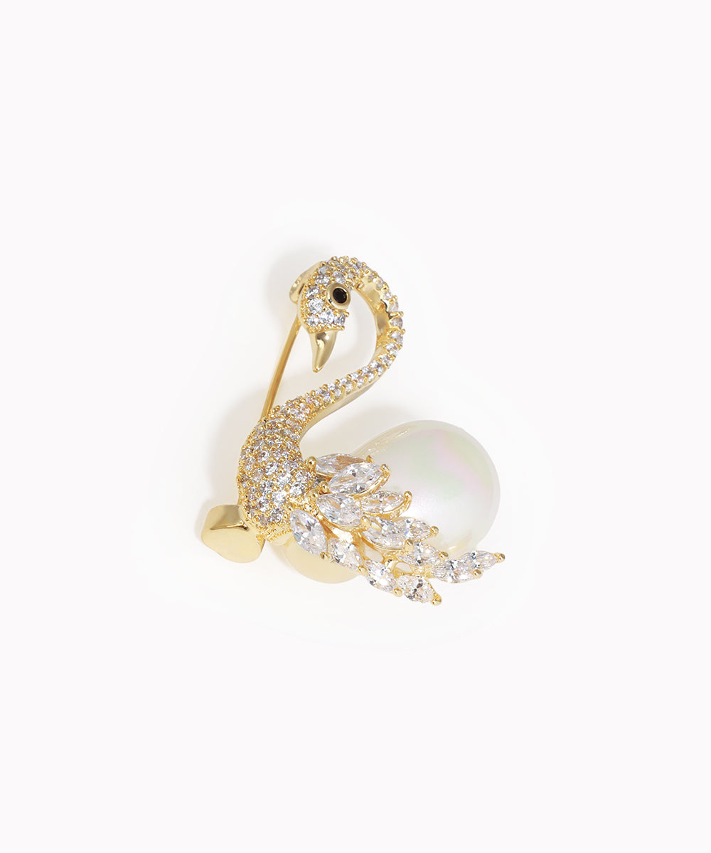 Gold-tone brooch with a swan design, clear stones, and an iridescent faux pearl.