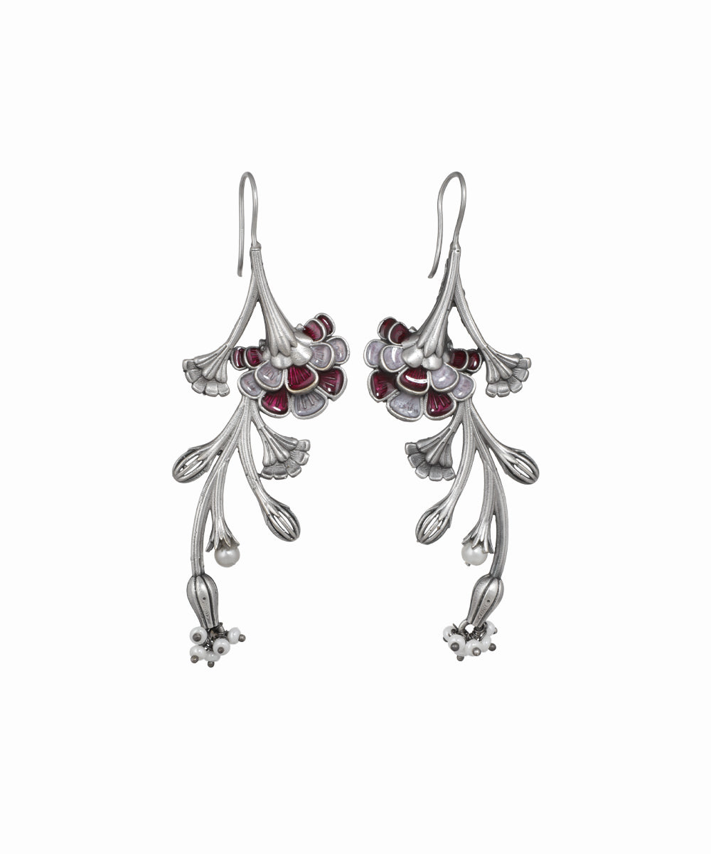 Silver floral earrings with red gemstones on a white background