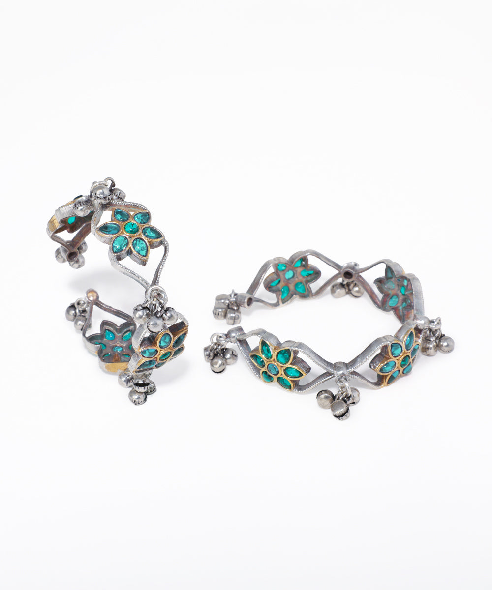 Pair of silver hoop earrings with turquoise gemstones on a white background