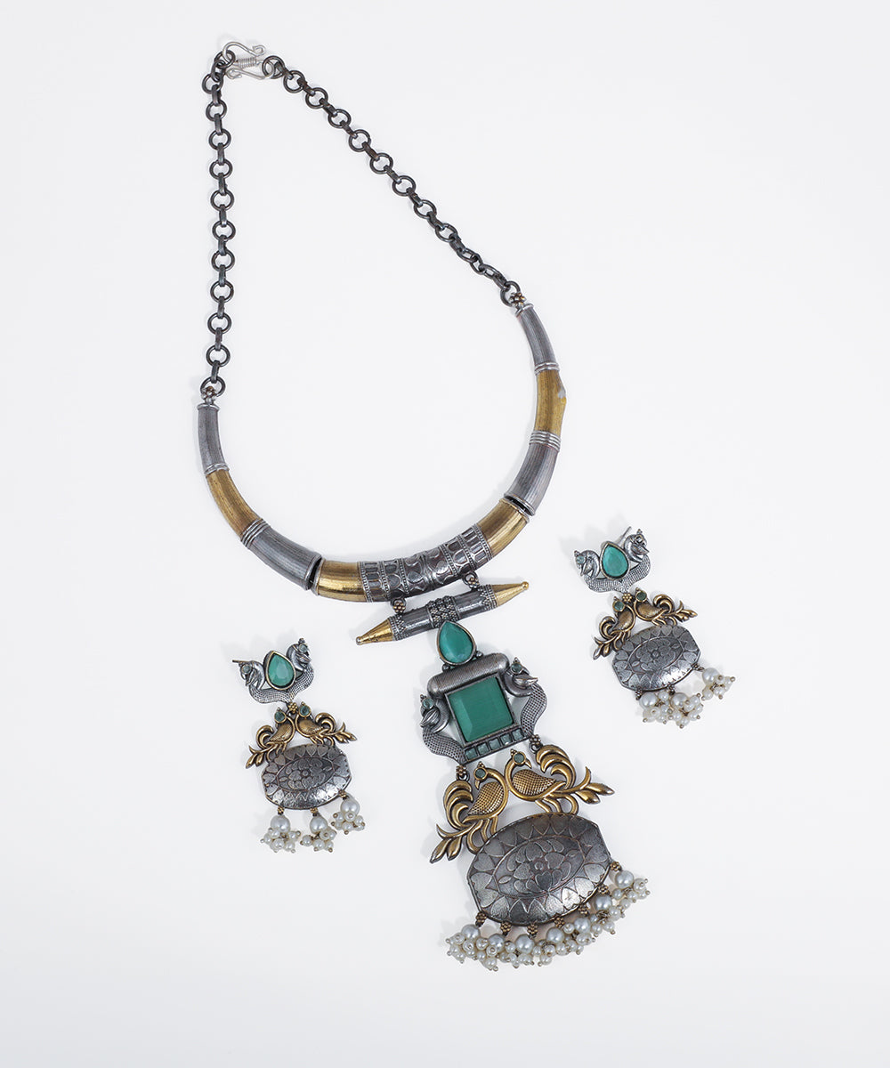 Oxidized silver-tone necklace set with antique gold-tone peacock motifs, green glass crystals, and faux pearl drops.