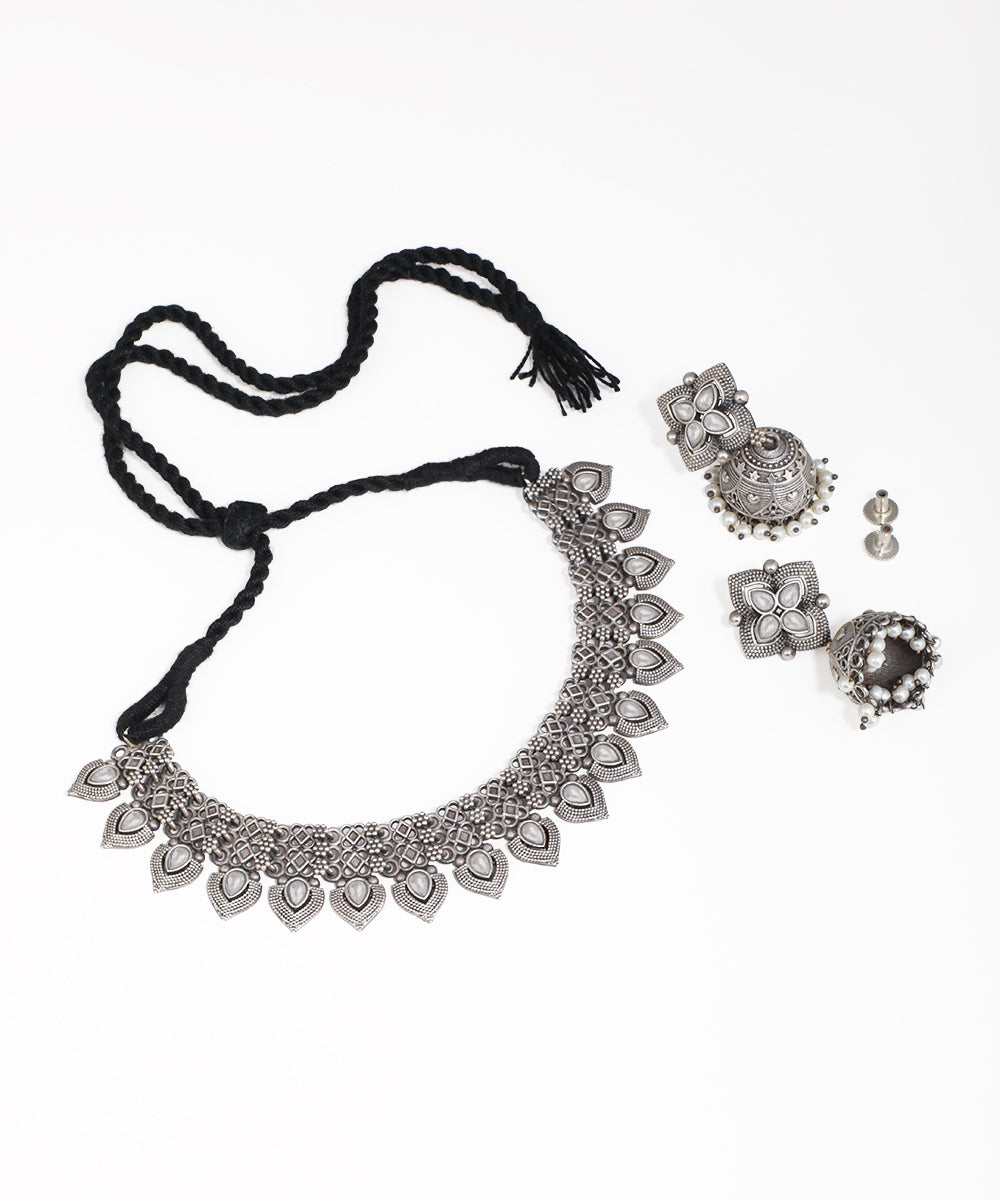 Silver necklace with tassel and matching earrings on a white background