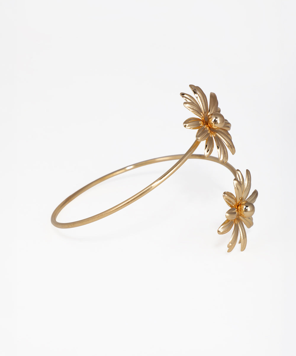 Gold bracelet with floral designs on a white background