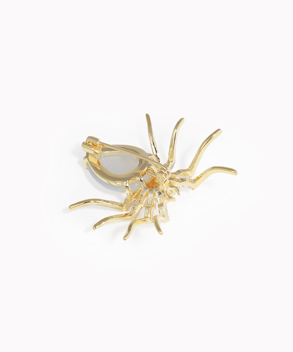 Gold spider-shaped earring on a white background