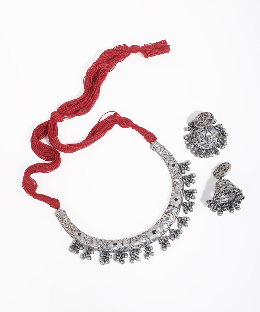 Silver necklace with matching earrings on a white background