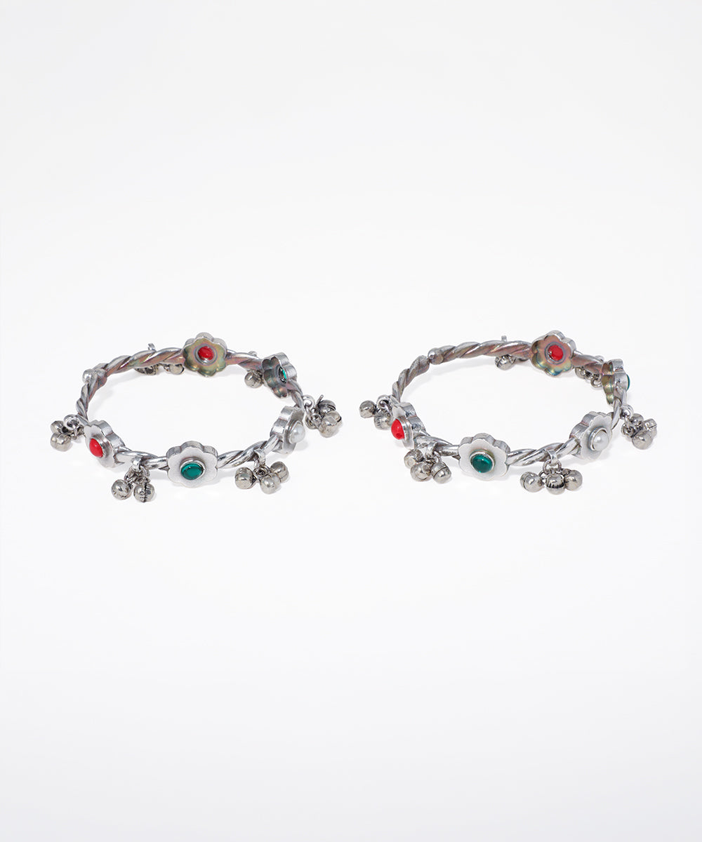 Pair of hoop earrings with colorful gemstones on a white background