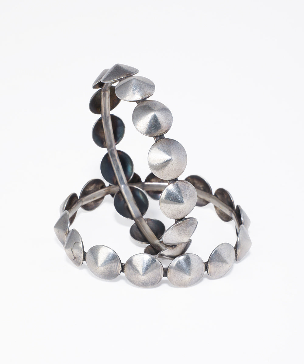 Oxidised silver-tone bangles with alternating flat discs and pointed stud details.
