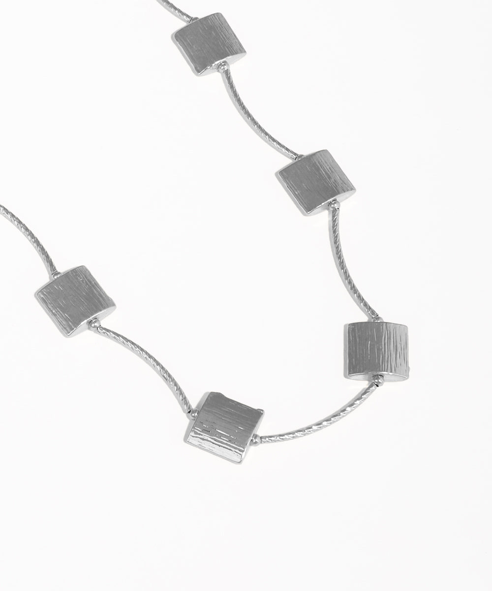 Silver necklace with square pendants on a white background