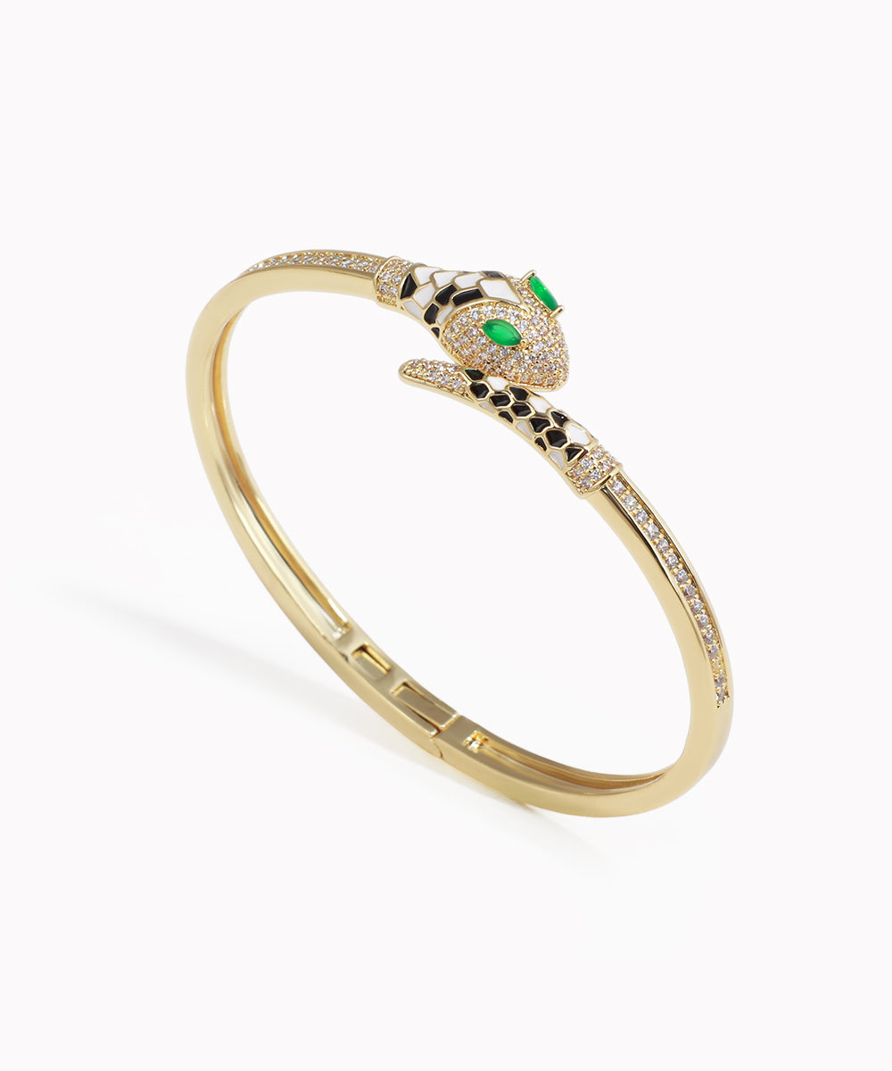 Gold-tone bracelet with paved serpent head, clear CZ stones, green eyes, and black & white enamel accents