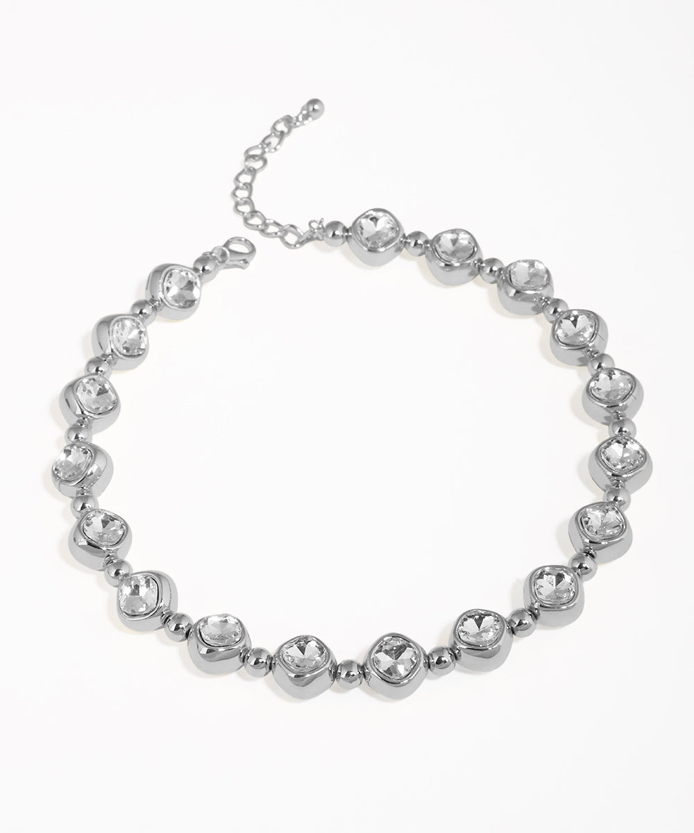 Silver bracelet with clear gemstones on a white background