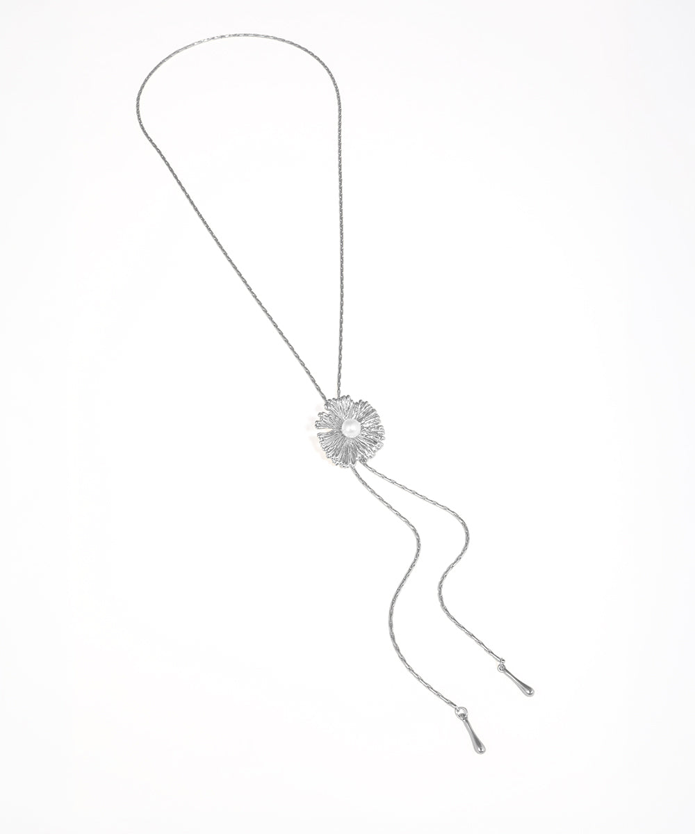 Silver necklace with a floral pendant on a white background