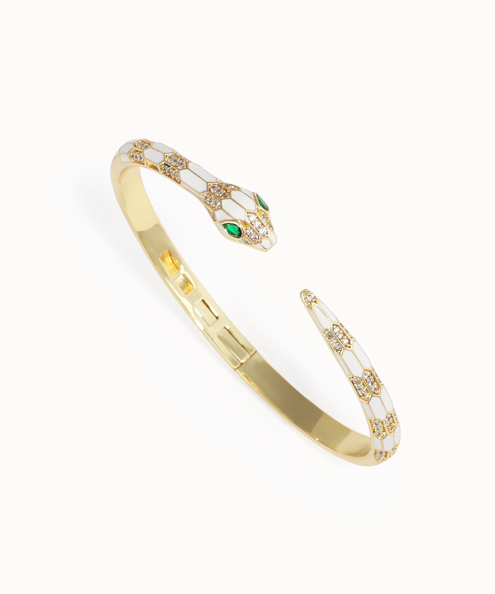 Gold bracelet with emerald stones on a white background