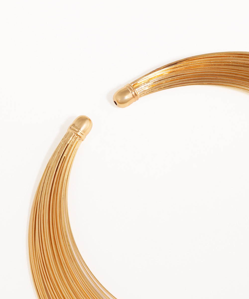 Gold wire coiled on a white background