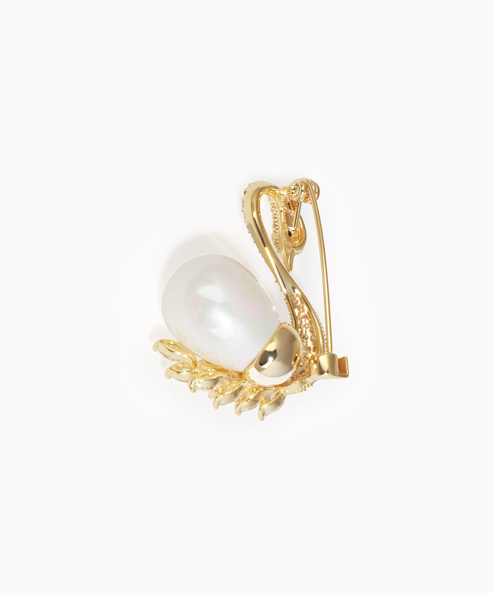 Gold brooch with a large pearl on a white background