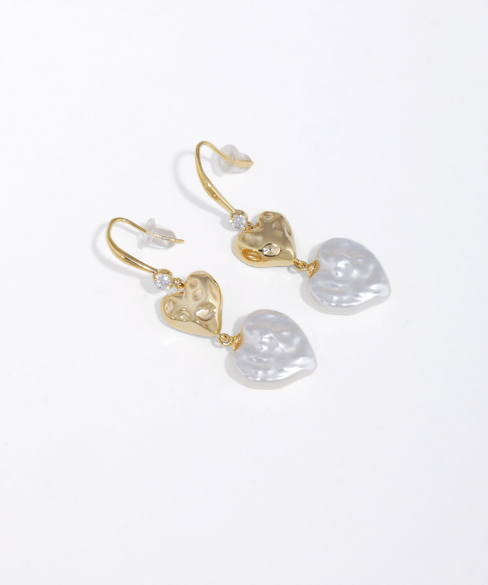Gold-tone drop earrings with hammered hearts and irregular faux pearl drops.
