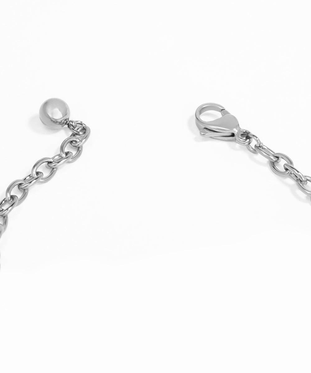 Close-up of a silver chain with a clasp on a white background
