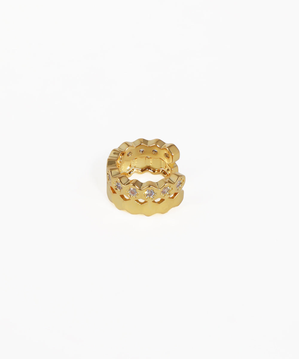 Gold ring with star-shaped stones on a white background