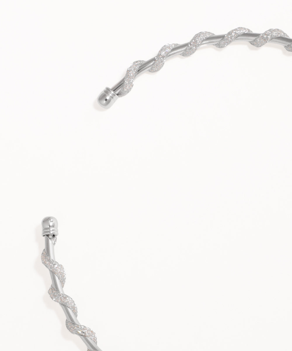 Silver bracelet with a textured design on a white background
