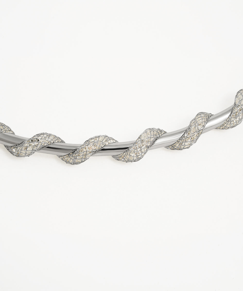 Silver bracelet with a twisted design on a white background