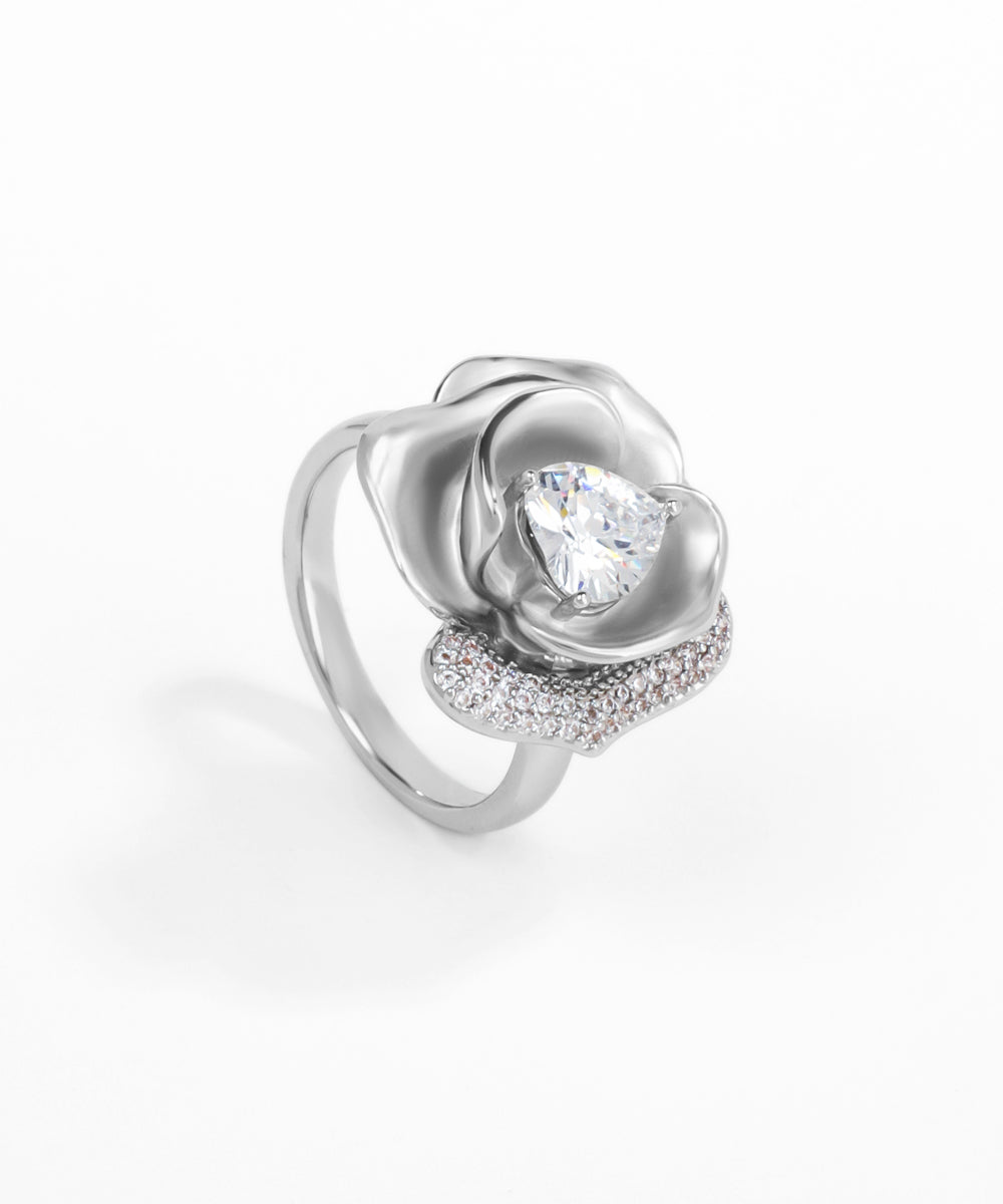Silver ring with a rose design and clear gemstone on a white background