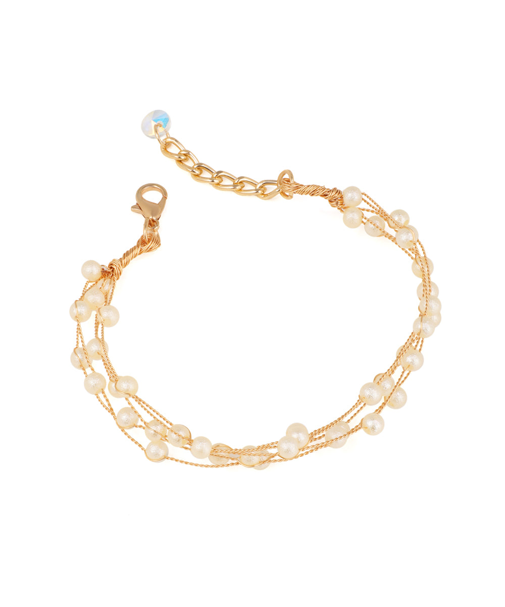 Gold-tone multi-strand bracelet with faux pearls and an iridescent bead on extender chain.