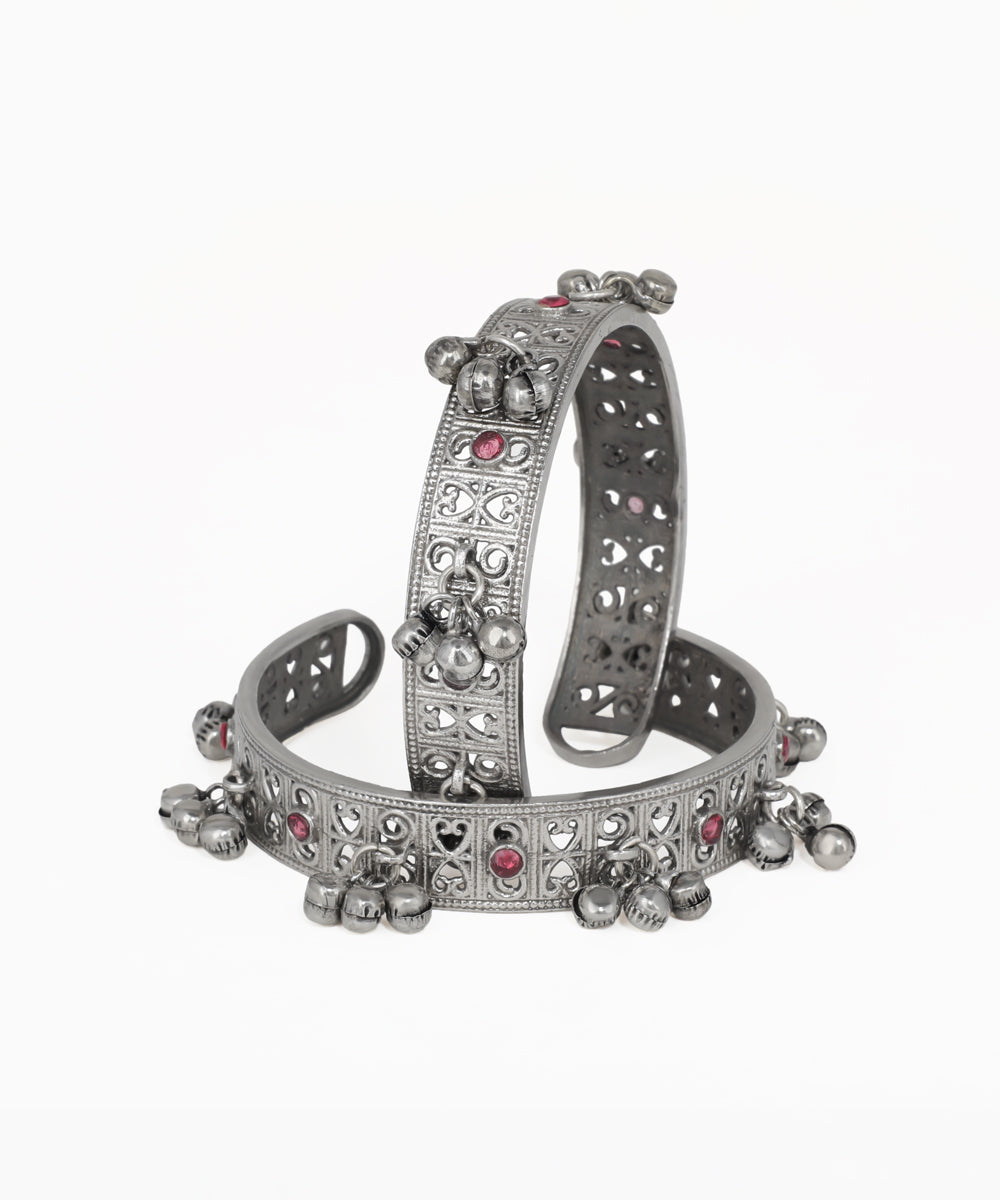 Silver bracelet with heart and round embellishments on a white background