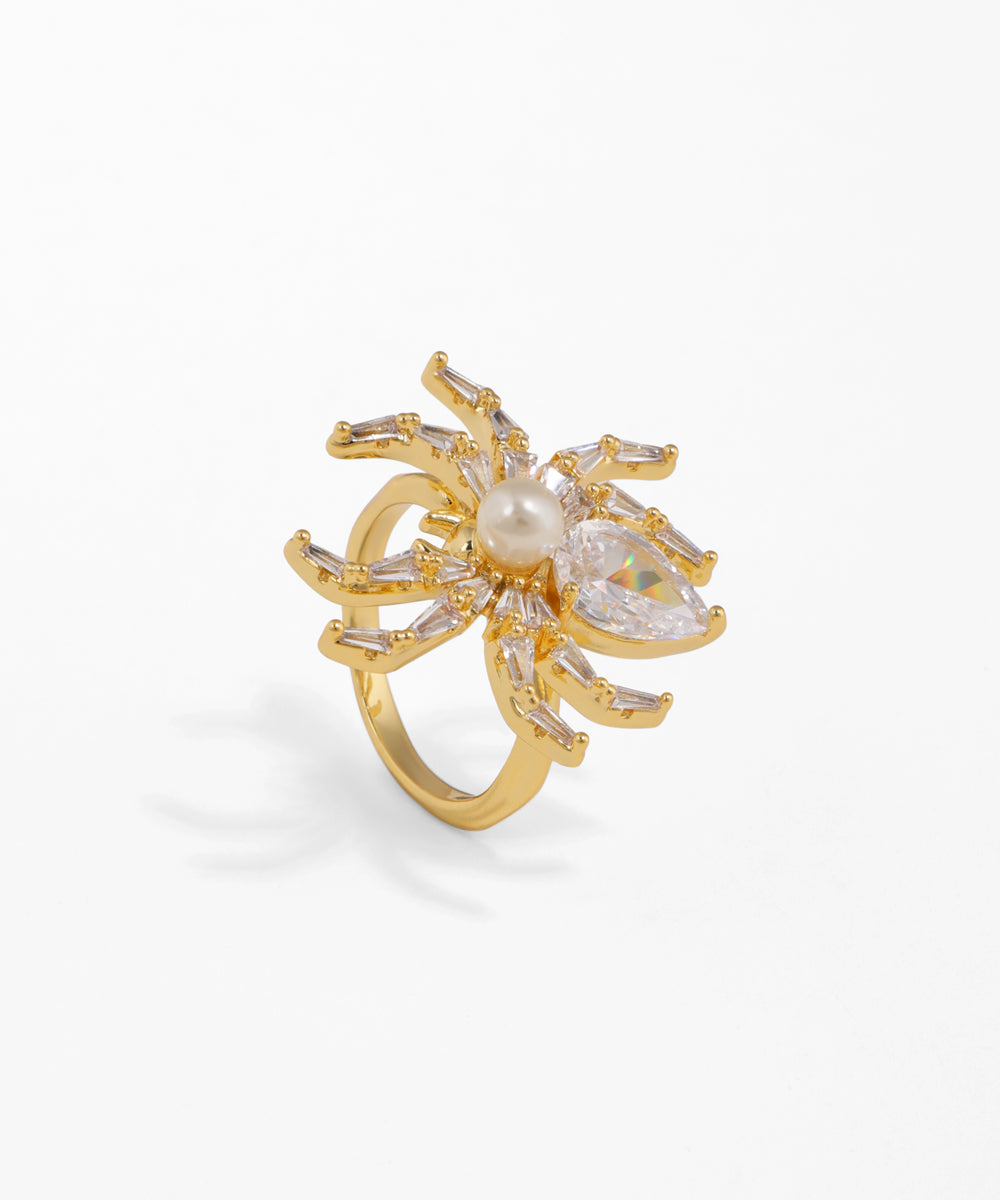 Gold ring with a central pearl and diamond-like stones on a white background
