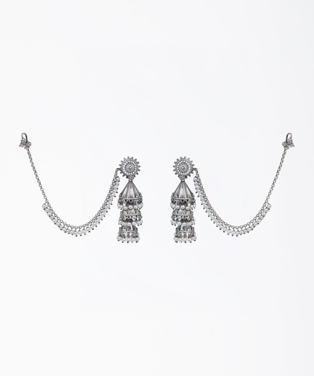 Oxidized silver-tone tiered jhumka earrings with faux pearls, CZ stones, and attached pearl ear chains.