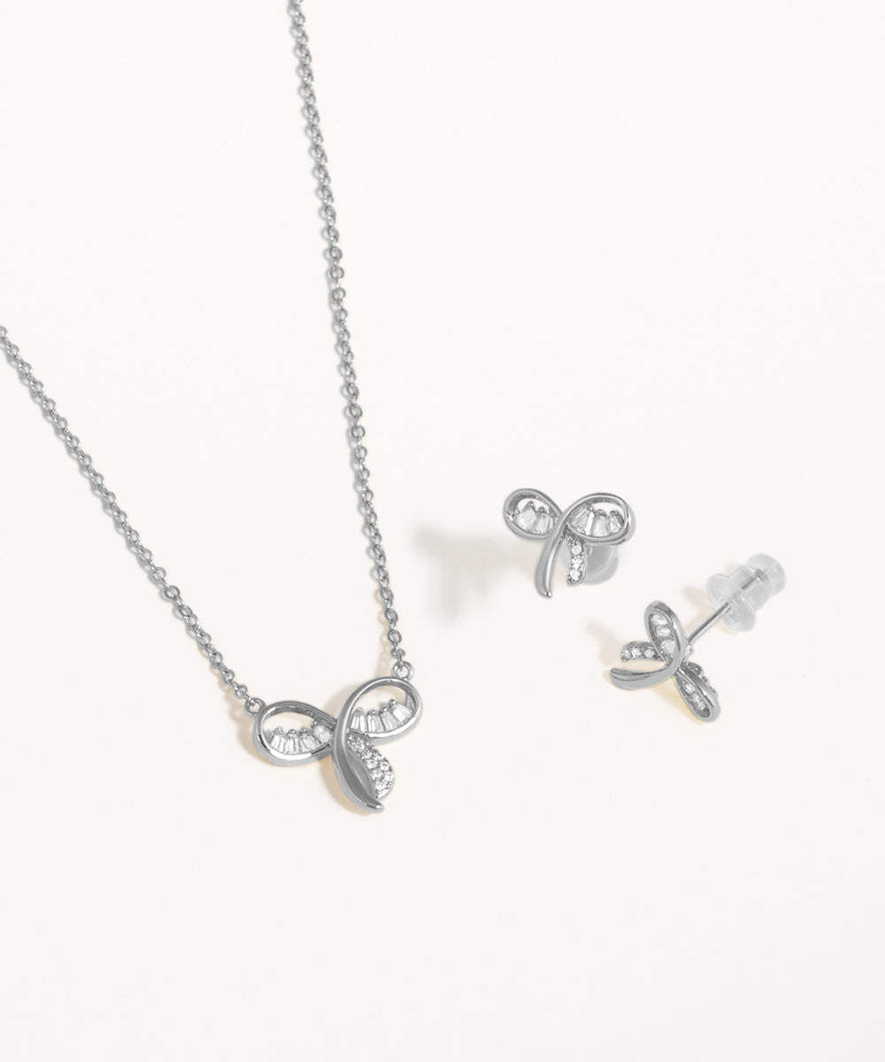 Silver bow-shaped necklace and earrings on a white background
