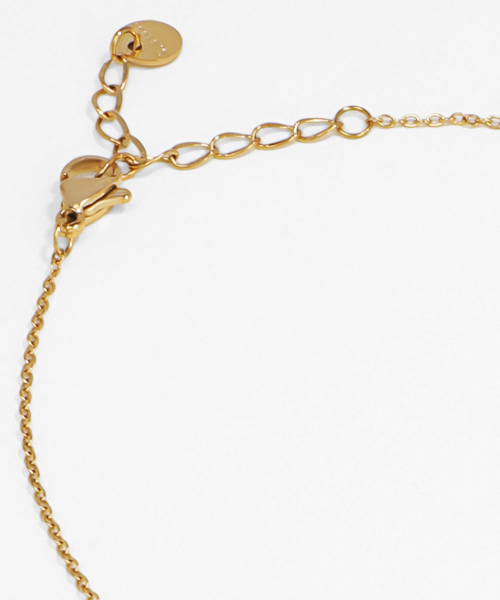 Gold bracelet with a heart charm on a white background