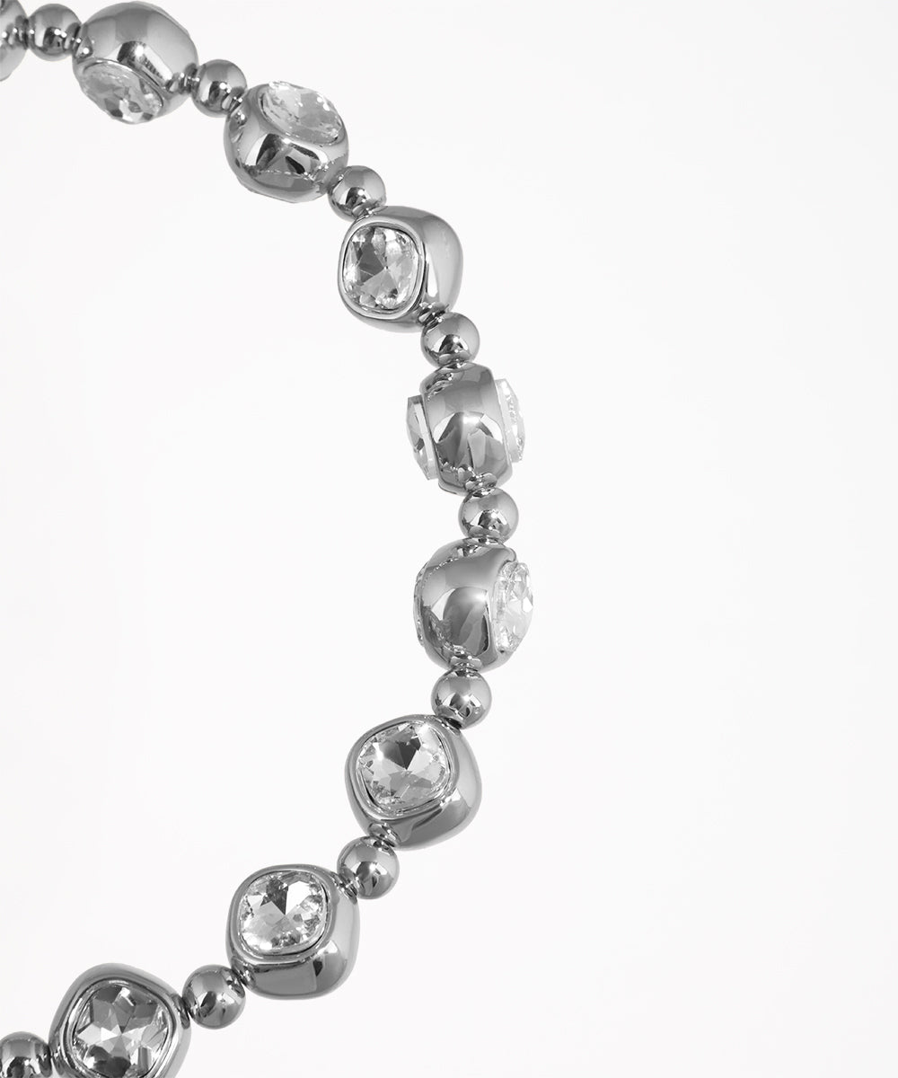 Silver bracelet with clear gemstones on a white background