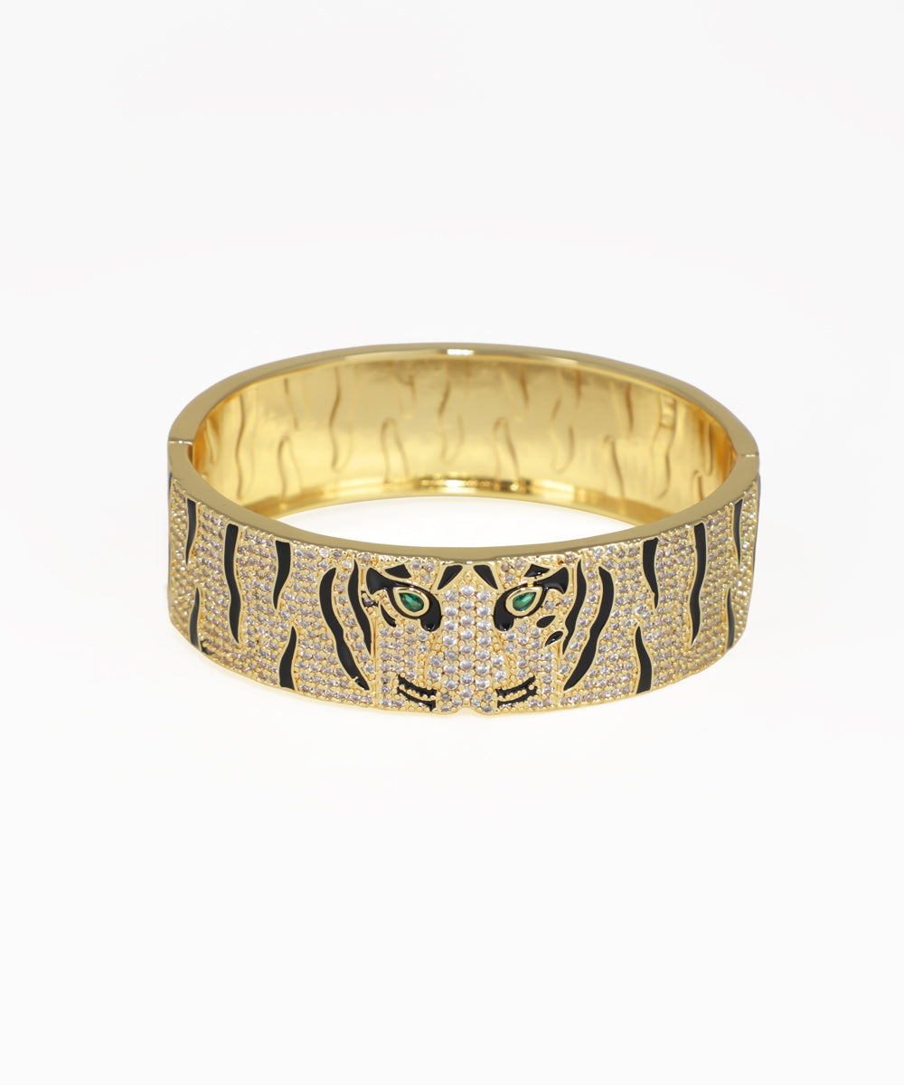 Gold bracelet with tiger design on a white background